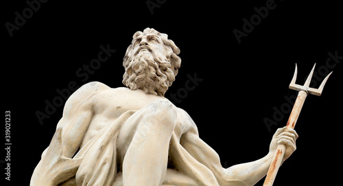 The ancient statue of god of seas and oceans Neptune (Poseidon) isolated on black background. photo