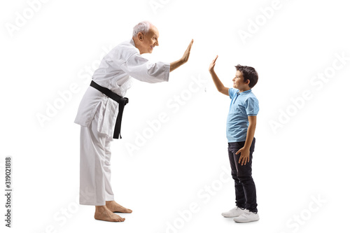 Boy and an elderly karate master gesturing high-five
