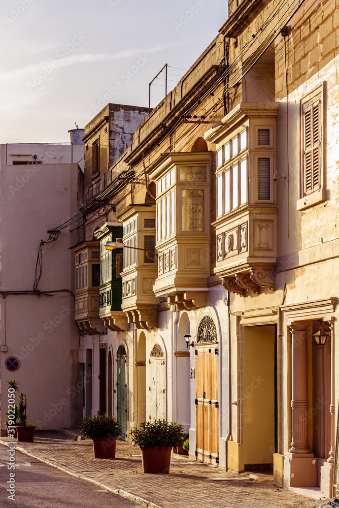 Fototapeta premium Small brown balconies in sunset rays in the late afternoon