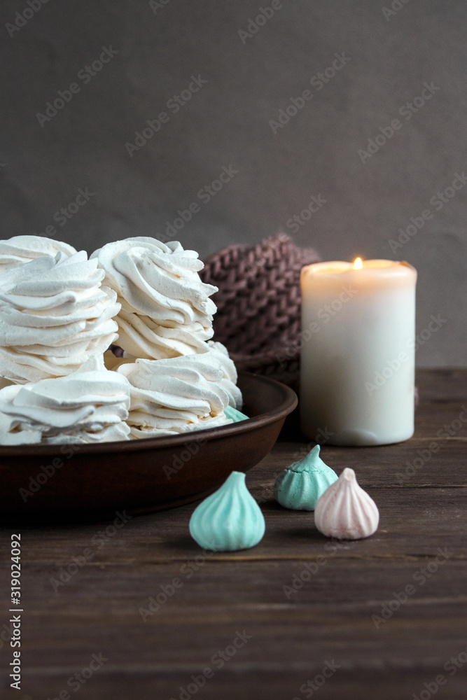 Handmade apple white homemade marshmallows on a brown plate and coffee in a black mug on a wooden table. Sweet zephyr and aromatic coffee. Handmade apple white homemade marshmallows on a brown plate and coffee in a black mug on a wooden table. Sweet zephyr and aromatic coffee.