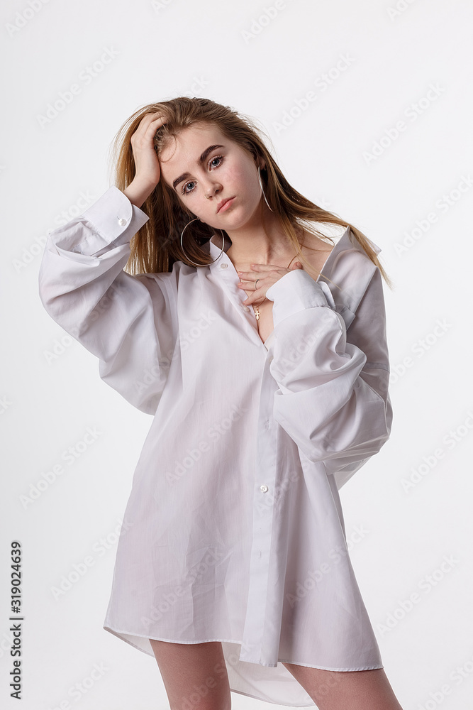 young thin pretty female wearing shirt posing in studio with bare