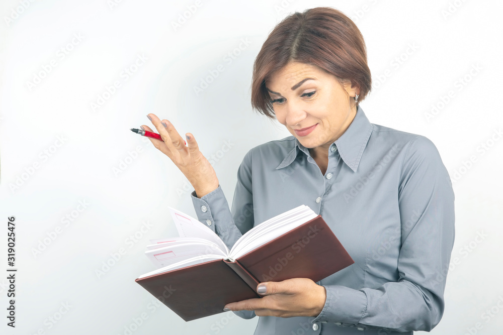 Beautiful young business girl with a red pen and notebook in hands on a white background Beautiful young business girl with a red pen and notebook in hands on a white background