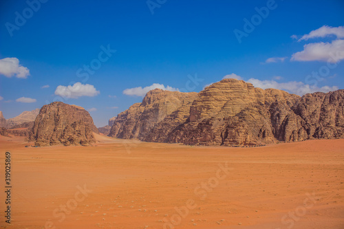picturesque colorful desert landscape Middle East heritage site scenic view sand valley foreground and stone rocks mountain ridge background in Jordan Wadi Rum