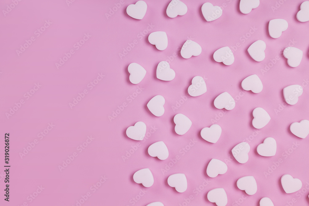 White pills in the shape of a heart scattered on a pink pastel background. Medecine and placebo concept White pills in the shape of a heart scattered on a pink pastel background. Medecine and placebo concept