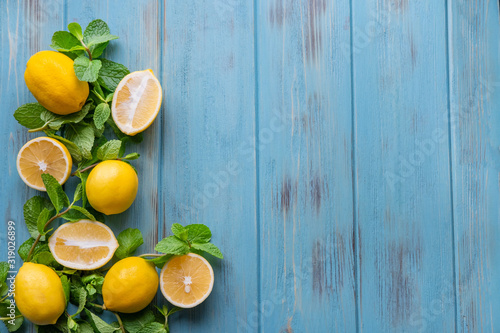 Lemons and mint on a blue wooden background. Vitamin C, lemonade, summer. Frame for post text for blog, discounts and cafe menu