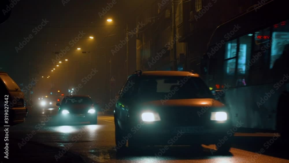 Foggy wet streets at night with traffic Foggy wet streets at night with traffic