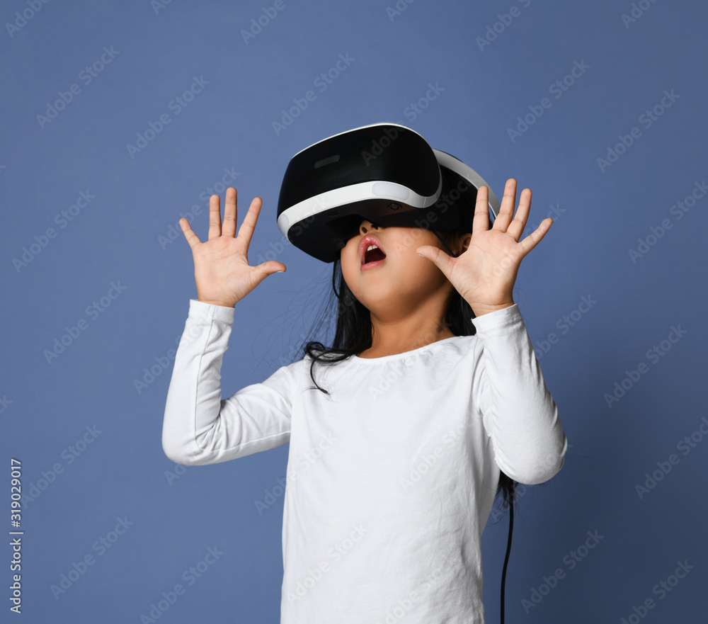 Young girl kid child play virtual reality game hold vr glasses and  surprised. Cyber space and virtual gaming foto de Stock | Adobe Stock