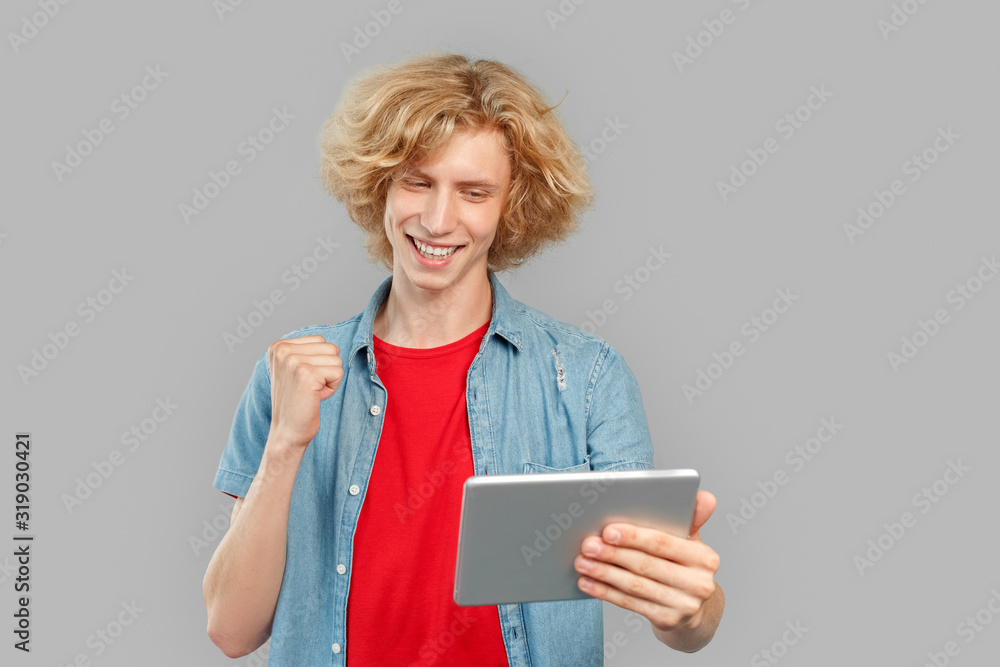 Young man using tablet computer and rejoiced Young man using tablet computer and rejoiced