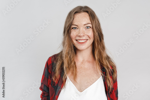 Freestyle. Young woman with freckles standing isolated on grey smiling playful close-up © Viktoriia