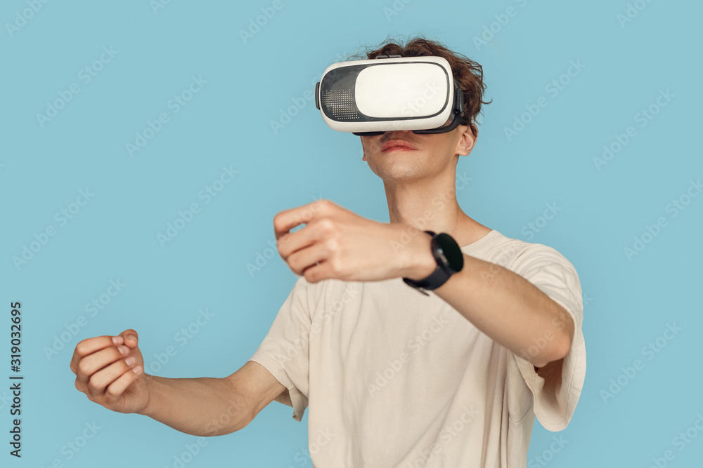 Freestyle. Man in vr headset standing isolated on gray playing game driving concentrated Freestyle. Man in vr headset standing isolated on gray playing game driving concentrated