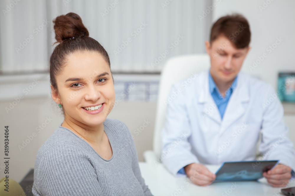 Close up of a happy healthy young woman smiling to the camera after medical appointment with her doctor at the hospital Close up of a happy healthy young woman smiling to the camera after medical appointment with her doctor at the hospital
