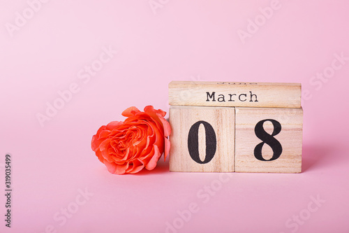 Calendar with date of International Women's Day and flower on color background