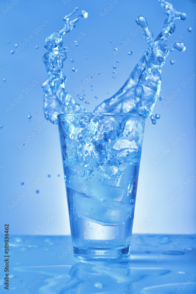 Glass of fresh water with splash on color background Glass of fresh water with splash on color background