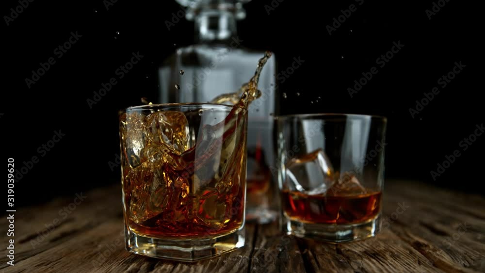 Super Slow Motion Shot of Ice Drop into Glass with Whiskey at 1000fps with Camera Movement. Super Slow Motion Shot of Ice Drop into Glass with Whiskey at 1000fps with Camera Movement.