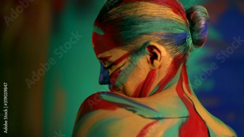 Woman with color face art and body paint. Colorful portrait of the girl with bright make-up and bodyart. photo