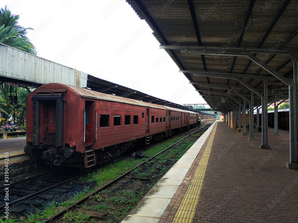 Empty platform of a railway station in Sri Lanka. Old rusty train cars. It looks like an abandoned place, but it’s not.