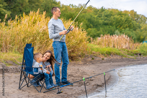 A happy family spends time together they teach their son to fish.