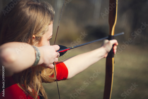 Fotografija Girls dressed as medieval teaching archery at the field