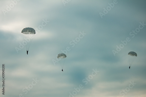 Army paratroopers jumping at air war action.