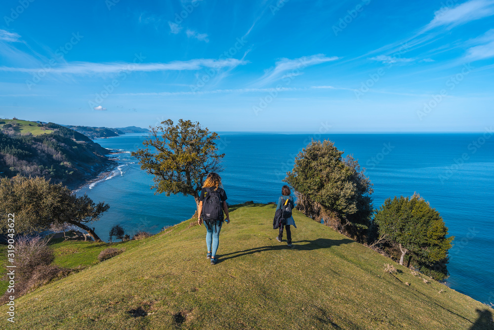 Deba, Gipuzkoa / Spain »; January 26, 2020: Two young people walking along the beautiful coast from Deba to Zumaia