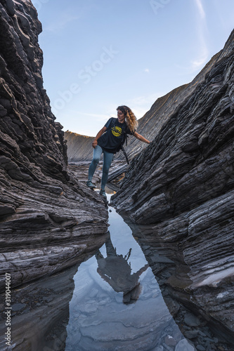 Deba, Gipuzkoa / Spain »; January 26, 2020: A young woman exploring the geopark of the Sakoneta coast one morning