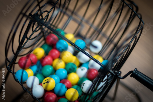 A bingo ball cage with colorful balls inside.  photo