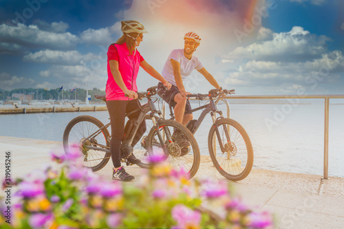 Active couple riding an E-Bike during vacations in the south