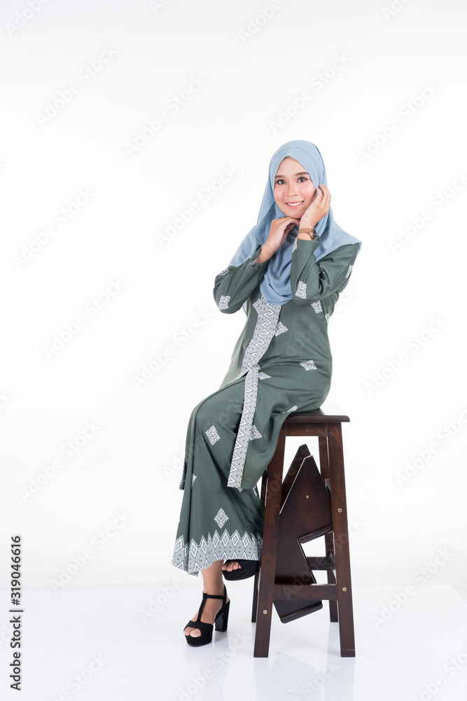 Fototapeta premium Beautiful female model in various poses wearing modern kebaya and hijab, a modern urban lifestyle apparel for Muslim women isolated on white background. Beauty and hijab fashion concept. Full length.