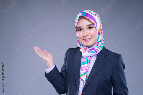Half length portrait of an attractive Muslim woman wearing business attire and hijab with mixed poses and gestures isolated on grey background. For image cut-out for technology, business or finance. © HEMINXYLAN
