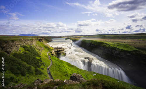 a picture of the impressive and gigantic waterfall gulfoss in iceland  taken during the blue hour on a cloudy day.