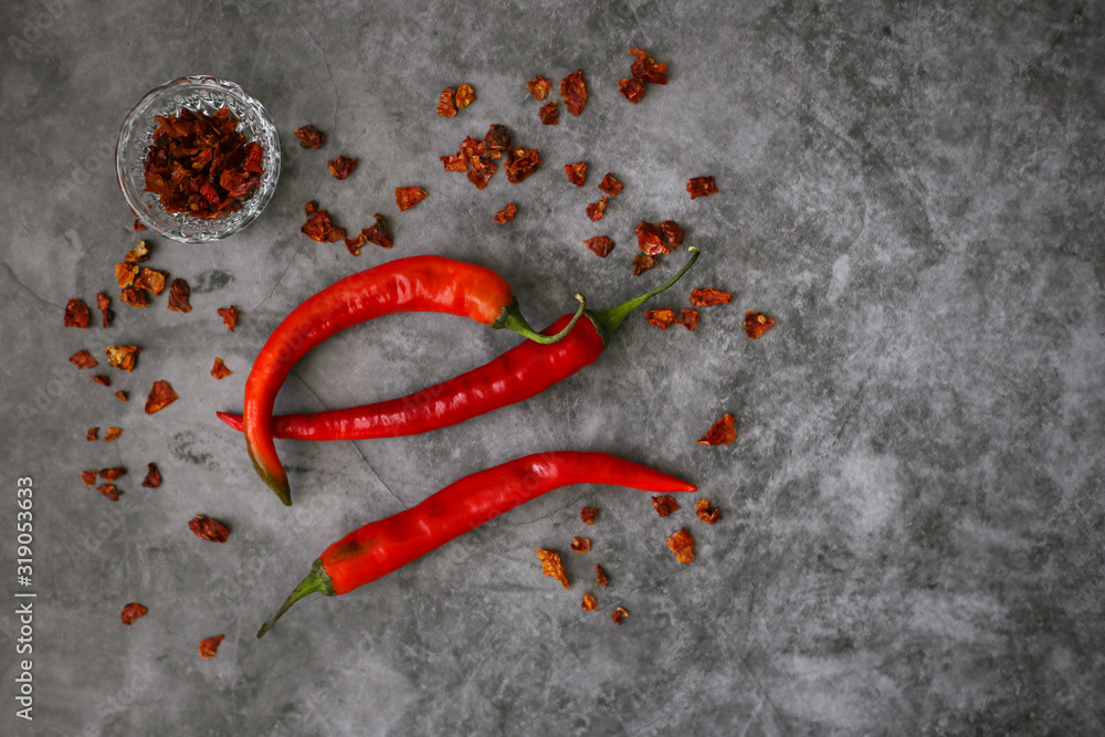 Three fresh red hot chilli peppers on a gray background, top view