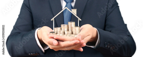 Growing coins house on stack coins in hand. Concept of Investment propert photo