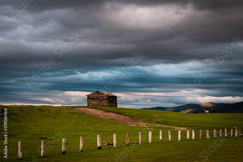 Storm clouds over log cabin