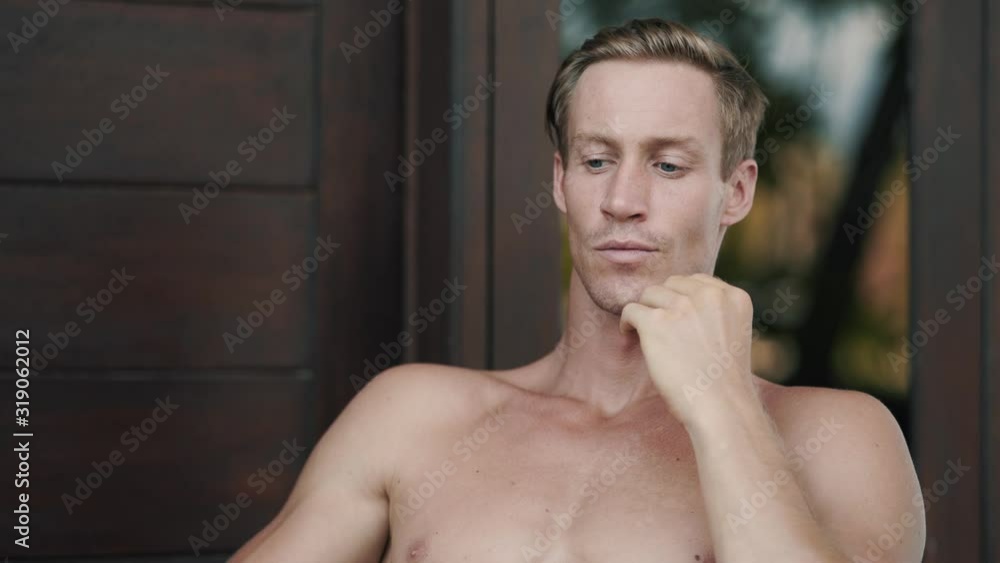 Portrait of handsome shirtless blond man looking at camera, smiling and flirting Portrait of handsome shirtless blond man looking at camera, smiling and flirting