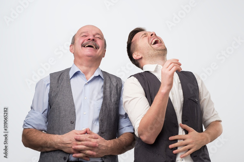 Two caucasian men laughing on his friends joke