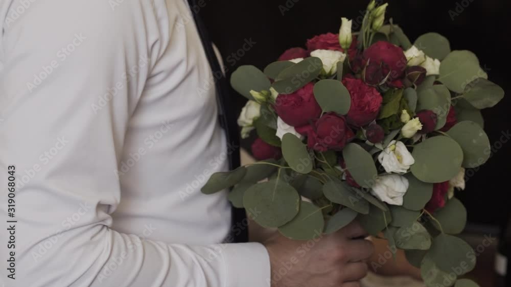 Young happy man holding a wedding bouquet in his hand. Young happy man holding a wedding bouquet in his hand.