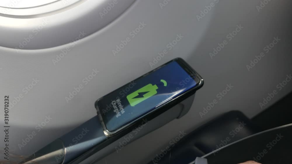 Wireless charging concept inside an airplane where the mobile phone charges once it is in contact with the armrest of the plane. Wireless charging concept inside an airplane where the mobile phone charges once it is in contact with the armrest of the plane.