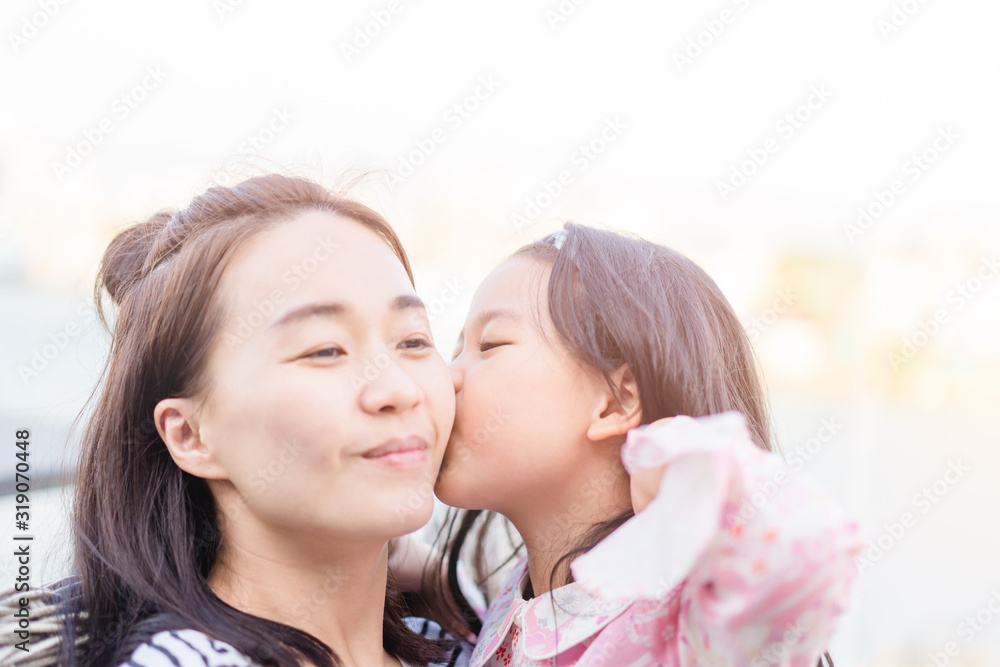 Happy loving asian family.Asian mother and child girl playing, kissing and hugging in sunset time.Laughing attractive asian mother and her cute little asian daughter at home. Happy loving asian family.Asian mother and child girl playing, kissing and hugging in sunset time.Laughing attractive asian mother and her cute little asian daughter at home.