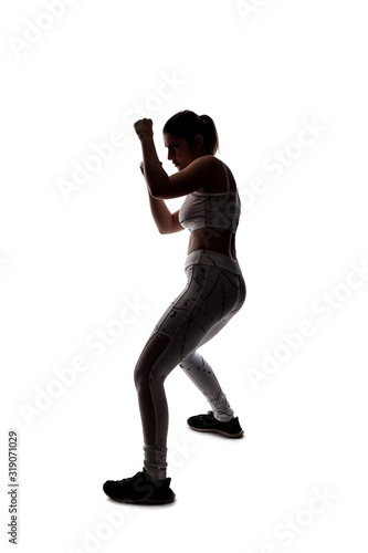 Valokuva Fit young woman in a fighting stance wearing athletic sports wear and exercising by punching or practicing self defense