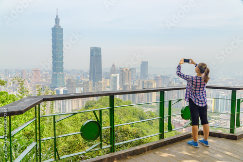 Young pretty female tourist taking pictures of Taipei, Taiwan