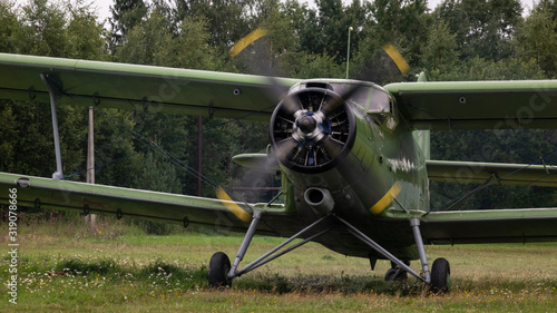 Agricultural airplane stands in a field in the green grass. photo