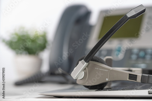 VOIP headset headphones telephone on laptop on office desk concept for communication, it support, call center and customer service help desk. Business center background, phone support service calls.