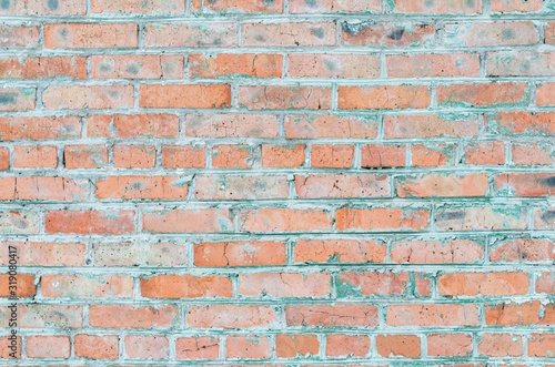 Brick wall. Old brick. Peeling paint. Light pink and gray.