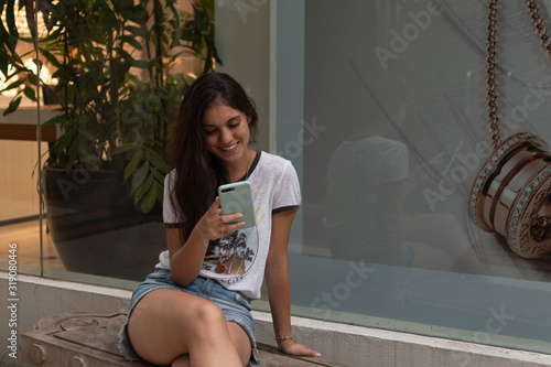 Young woman sending a message with the mobile