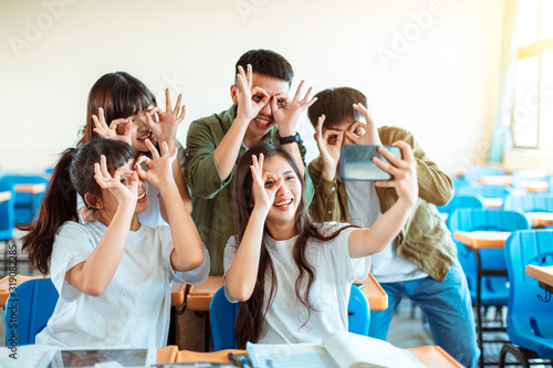 happy young group of teenagers making fun selfie in classroom