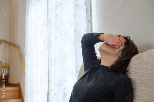 ソファでぐったりする女性 頭痛 疲労 子育て 生理痛