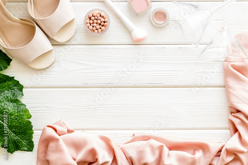 Women fashion concept. Dress, shoes, cosmetics on white wooden background top-down frame copy space