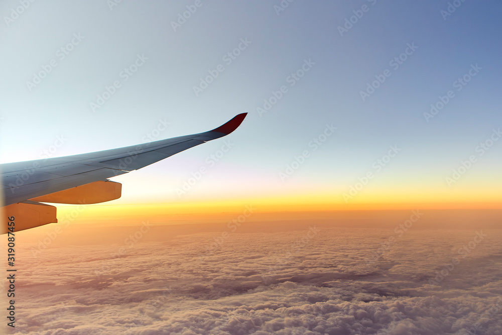 Obraz premium Wing of an aeroplane with sunset