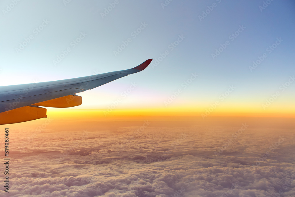 Obraz premium Wing of an aeroplane with sunset