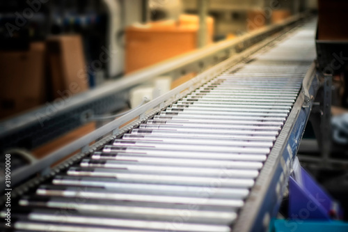 Fully automated logistics warehouse with a conveyor belt. Background is blurred. It is a modern storage photo